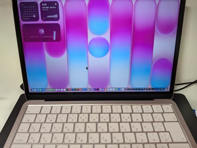 MacBook Neoを開いた状態。ピンクゴールド系の本体に白いキーボード